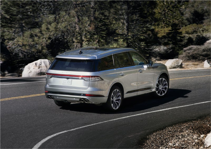 A 2023 Lincoln Aviator® Grand Touring model is shown being driven on a tight turn of a mountain road | Steet-Ponte Lincoln in Yorkville NY
