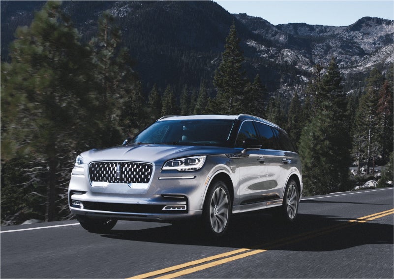 A 2023 Lincoln Aviator® Grand Touring SUV being driven on a winding road to demonstrate the capabilities of all-wheel drive | Steet-Ponte Lincoln in Yorkville NY