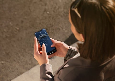 A person is shown interacting with a smartphone to connect to a Lincoln vehicle via the Lincoln Way® App. | Steet-Ponte Lincoln in Yorkville NY