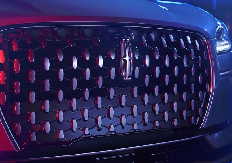 The grille of a 2025 Lincoln Corsair® SUV reflects neon light at night. | Steet-Ponte Lincoln in Yorkville NY