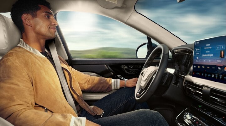 A person is shown using Lincoln BlueCruise hands-free highway driving technology on a divided highway called a Hands-Free Blue Zone. | Steet-Ponte Lincoln in Yorkville NY