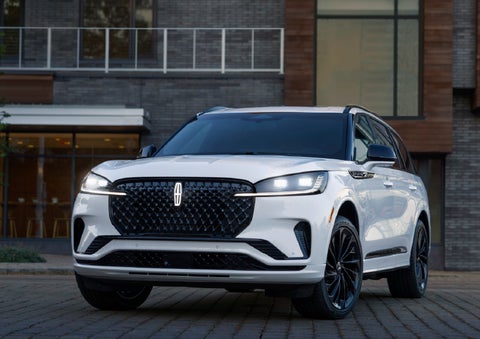 A 2026 Lincoln Aviator® Reserve model is shown with the available Jet Appearance Package parked near a restaurant. | Steet-Ponte Lincoln in Yorkville NY