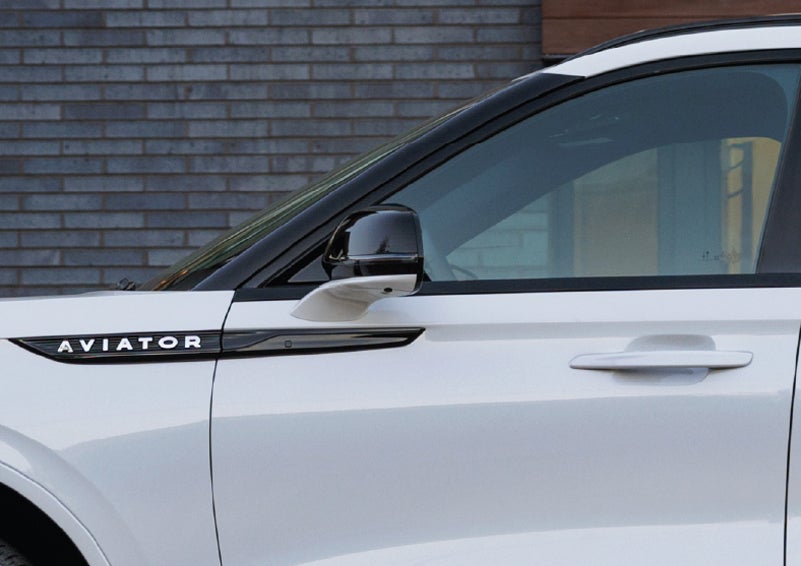 The driver’s side door and fender badging of a white 2026 Lincoln Aviator® SUV are showcased. | Steet-Ponte Lincoln in Yorkville NY