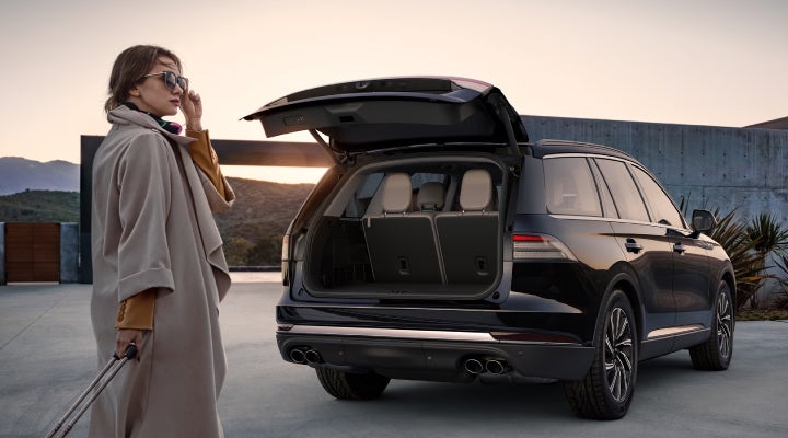 A woman approaches a 2026 Lincoln Aviator® SUV with its rear liftgate open. | Steet-Ponte Lincoln in Yorkville NY