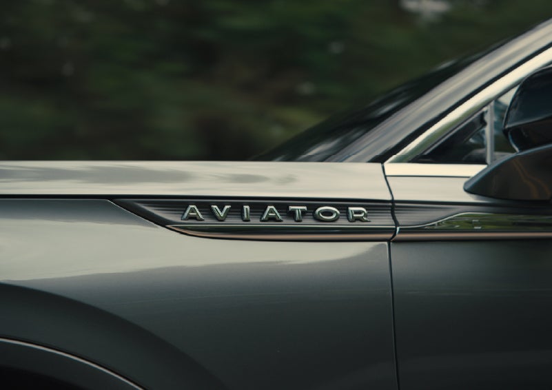 The driver’s side door and fender badging of a gray 2027 Lincoln Aviator® SUV are showcased. | Steet-Ponte Lincoln in Yorkville NY