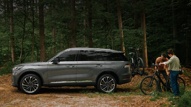 A father and son load e-bikes on a bike rack attached to a 2027 Lincoln Aviator® SUV. | Steet-Ponte Lincoln in Yorkville NY