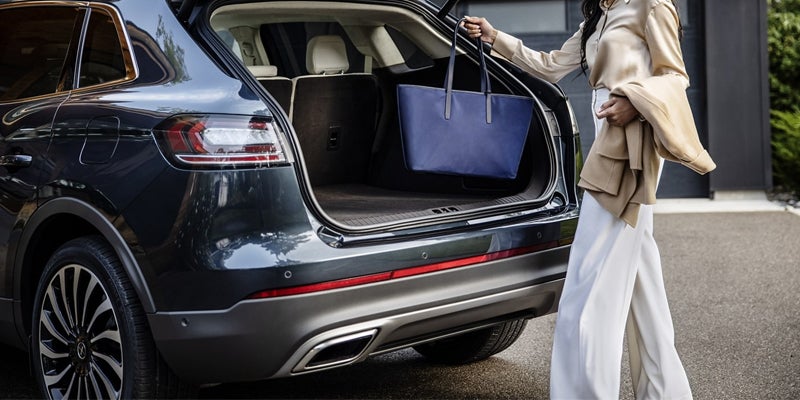 Lady putting bag in back of a 2024 Lincoln Nautilus in Yorkville, NY